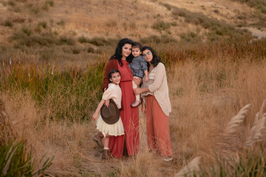 Mother and her three daughters in Bay Area's golden field posing for photos