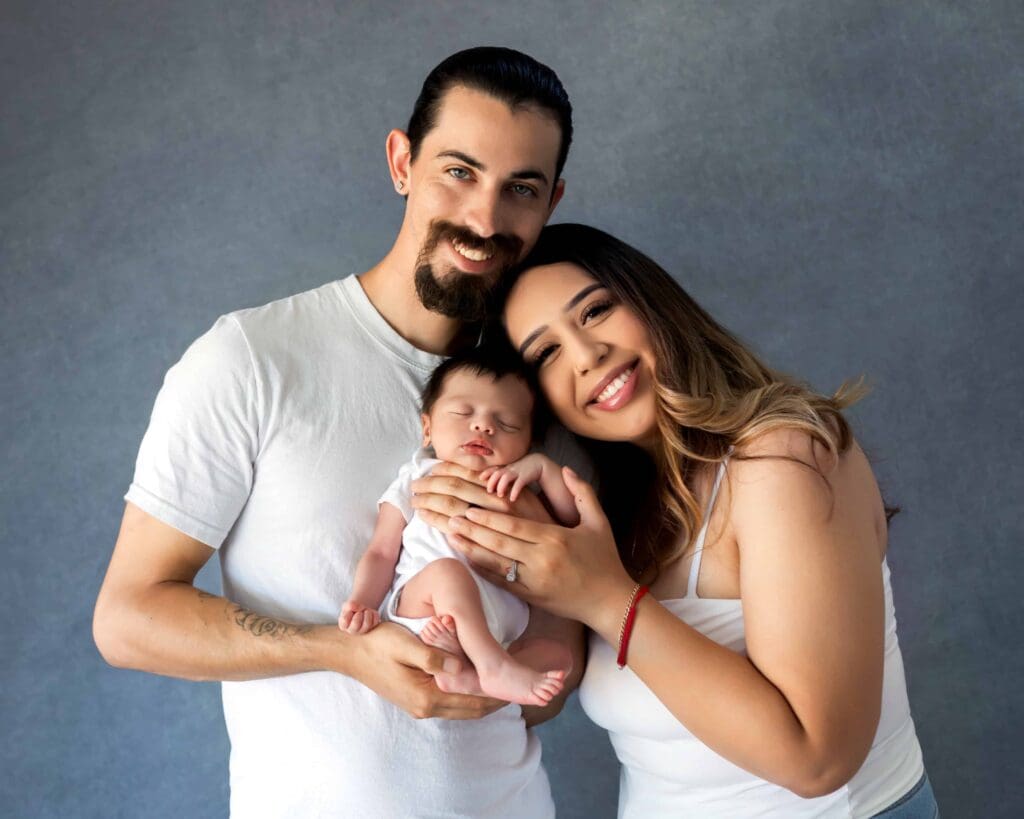 Mom and dad happy snuggling their newborn baby for a photoshoot in bay area