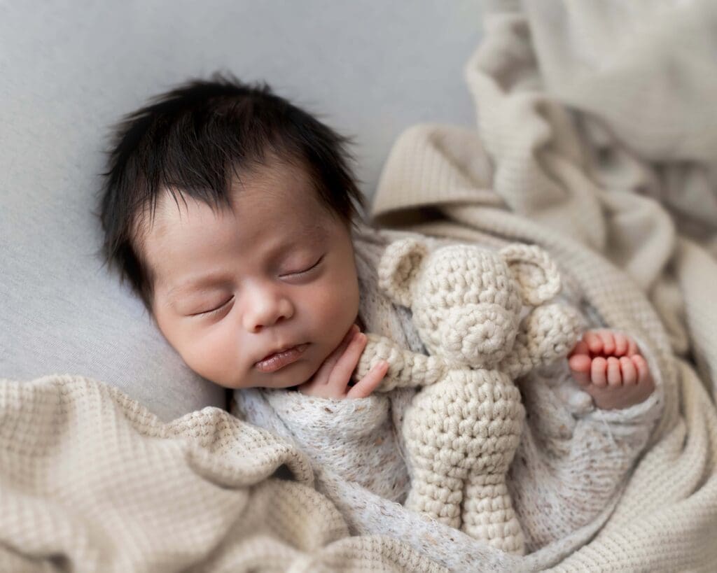 Newborn sleeping swaddled softly during in-home Bay Area photo session