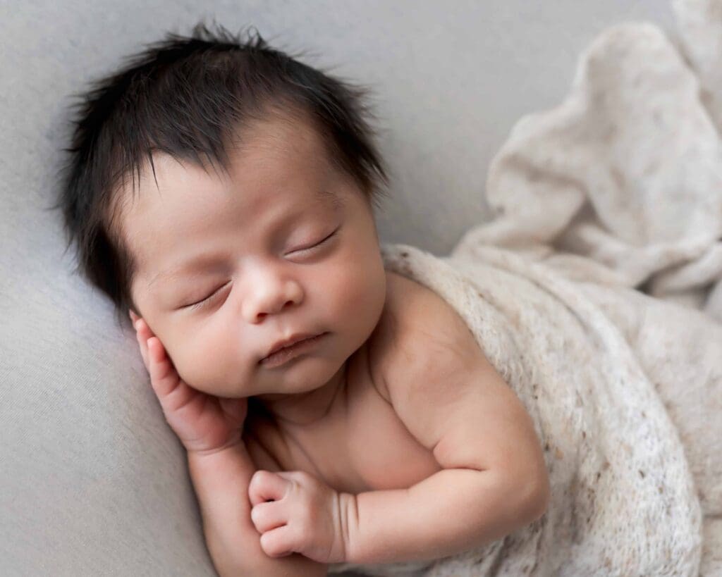 Sweet newborn baby sleeping during his newborn photoshoot