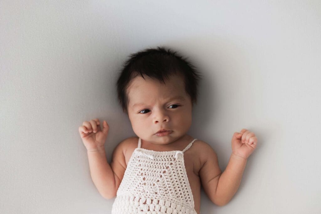 Newborn sleeping on neutral fabric during in-home Bay Area photo session