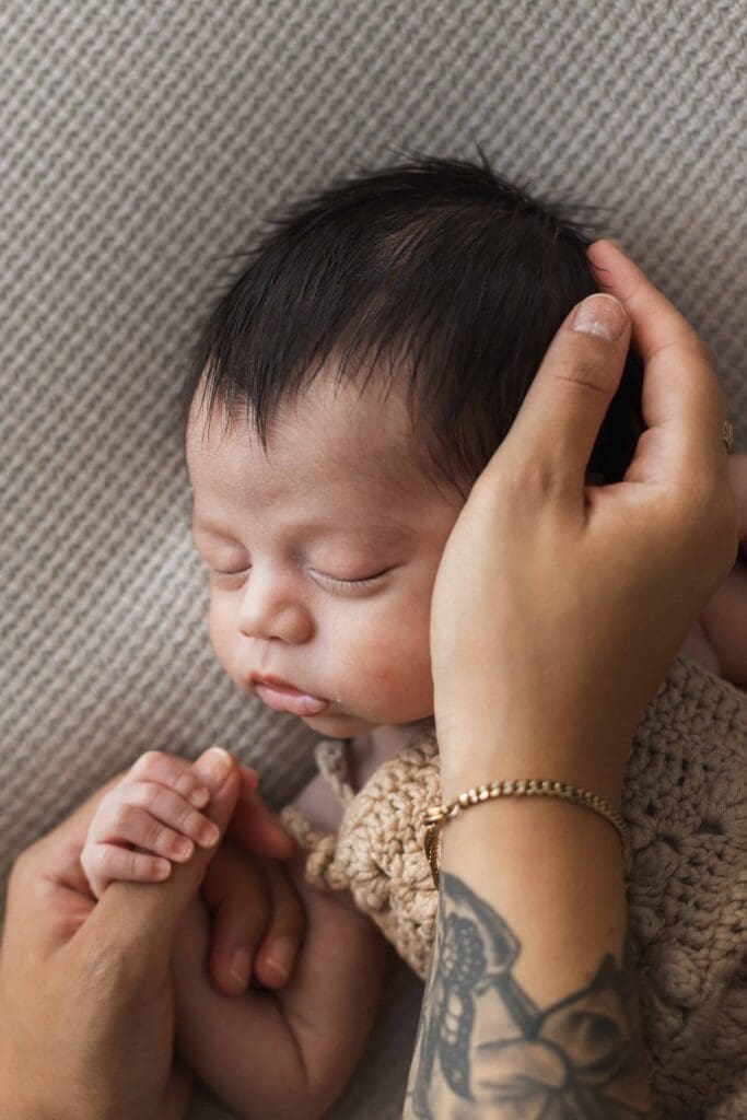 Newborn fingers holding mother’s hand in timeless lifestyle photograph